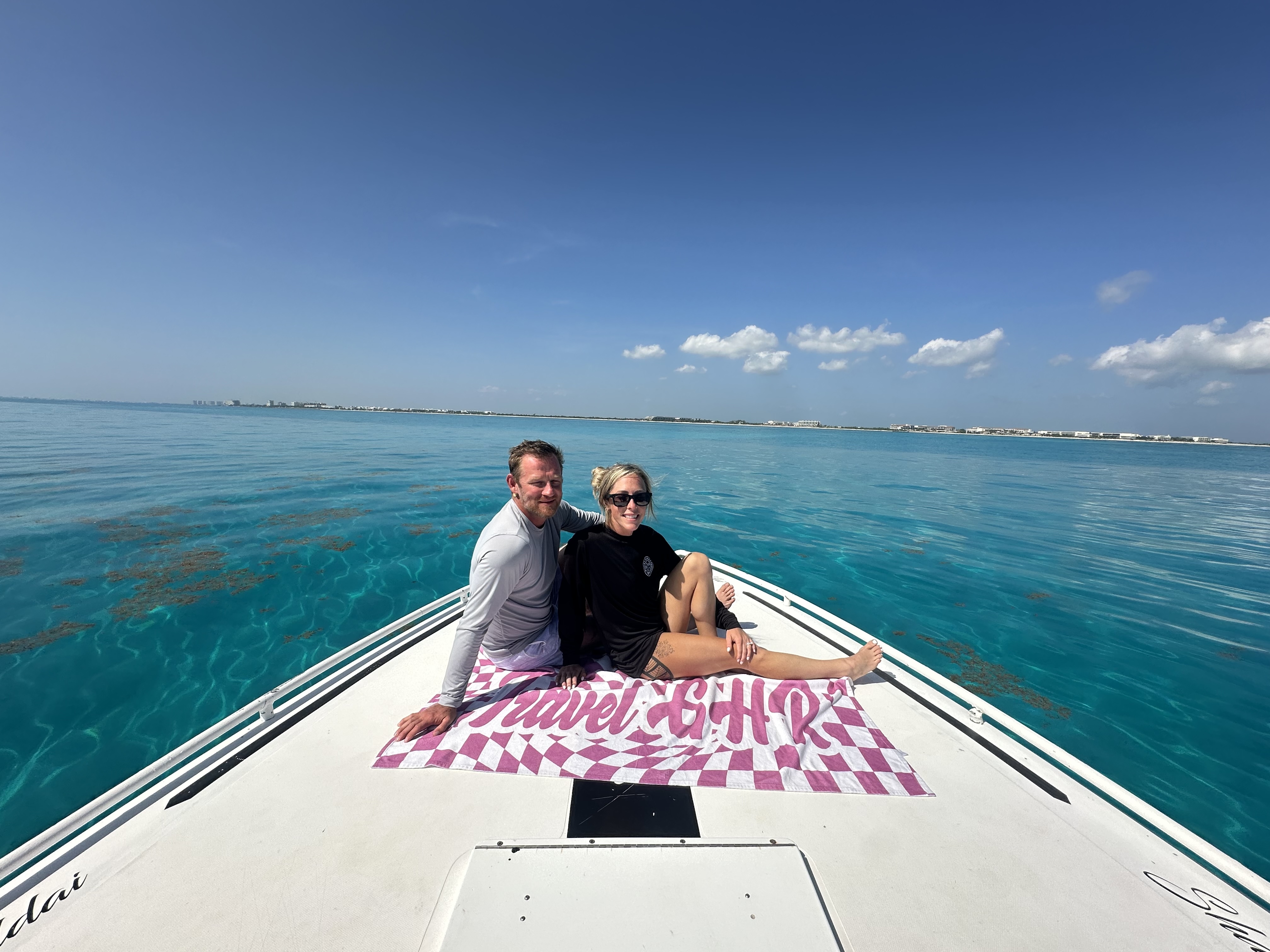 Travel GHR clients on a private boat charter over turquoise water near Isla Mujeres, Mexico