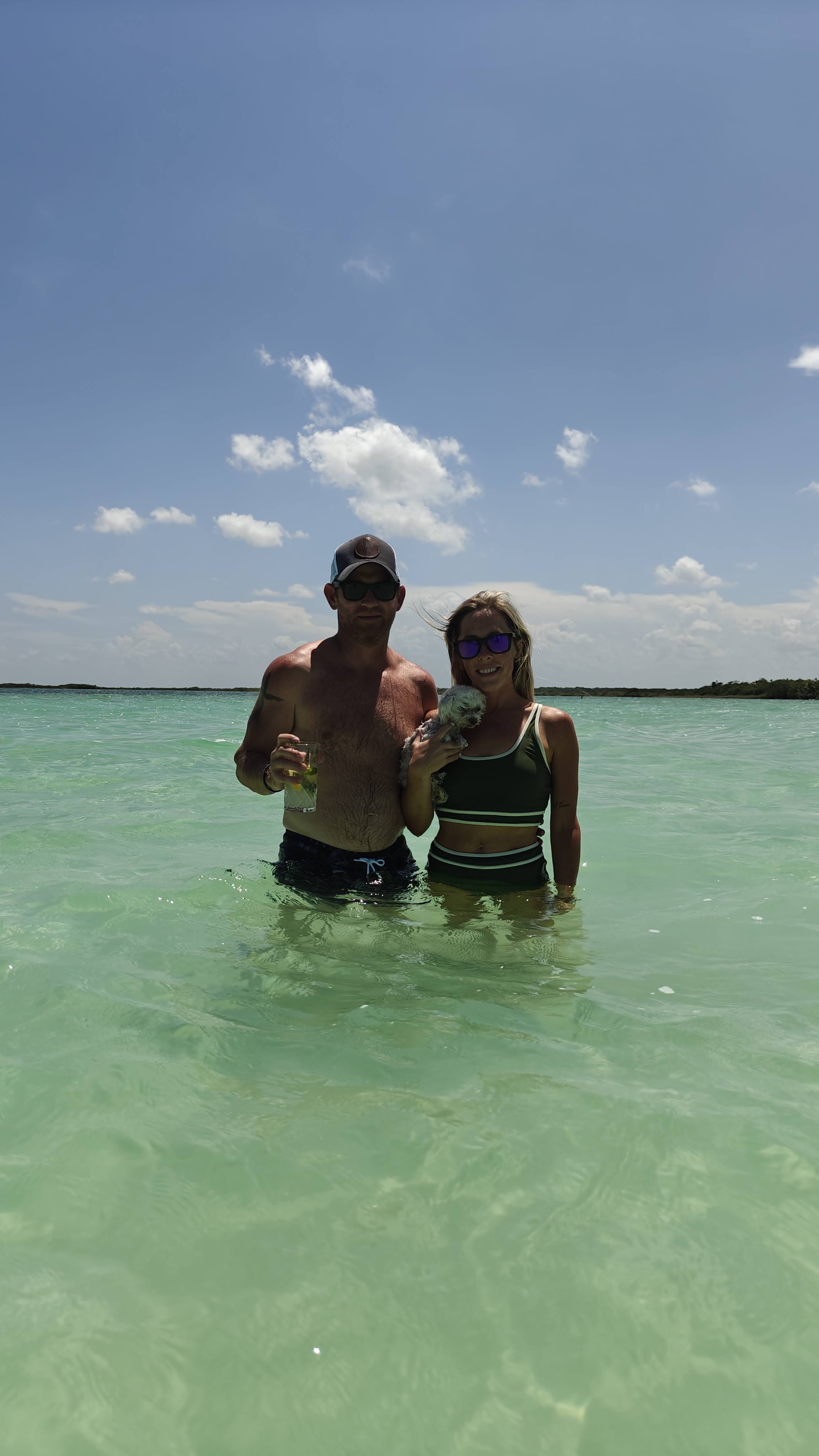 Family standing in a clear shallow lagoon in Holbox, Mexico